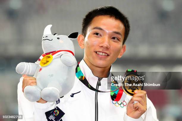 Gold medalist Hiroto Inoue of Japan celebrates on the podium at the medal ceremony for the Men's Marathon at the GBK Main Stadium on day seven of the...