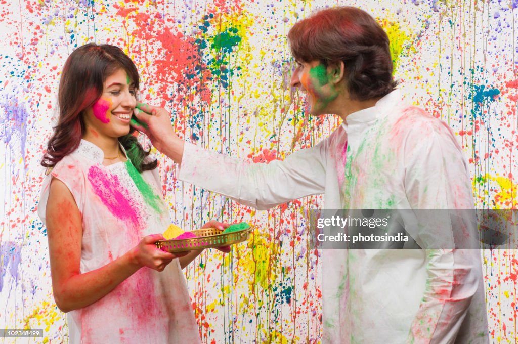 Man applying colors on a woman's face