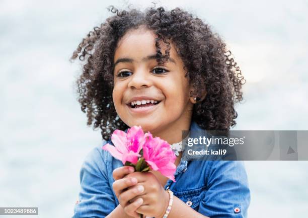 mixed race african-american, hispanic girl with flower - giving a girl head stock pictures, royalty-free photos & images