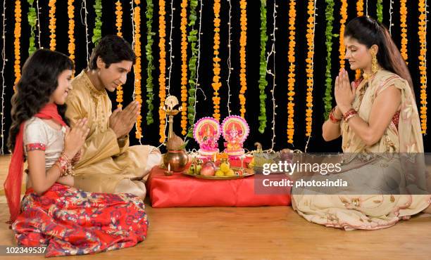 family doing diwali pooja - diwali decoration stock pictures, royalty-free photos & images