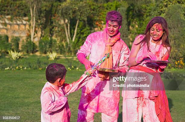 family celebrating holi with colors - water pistol stock pictures, royalty-free photos & images