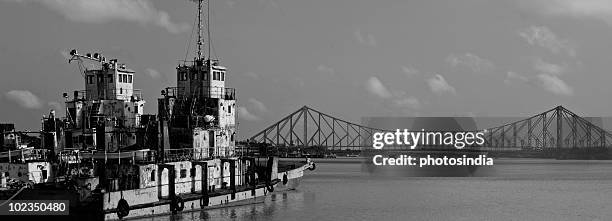boat with a bridge in the background, howrah bridge, hooghly river, kolkata, west bengal, india - howrah bridge stock pictures, royalty-free photos & images