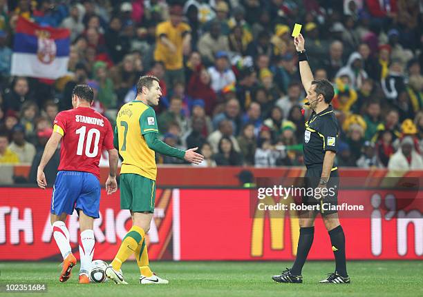 Brett Emerton of Australia receives a yellow card from referee Jorge Larrionda during the 2010 FIFA World Cup South Africa Group D match between...