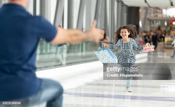 beautiful little girl greeting her dad at the airport running towards him excited and happy - arrival hug stock pictures, royalty-free photos & images