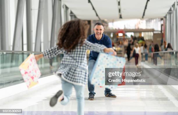 loving father greeting his little daughter at the airport while she runs towards him - returning gift stock pictures, royalty-free photos & images