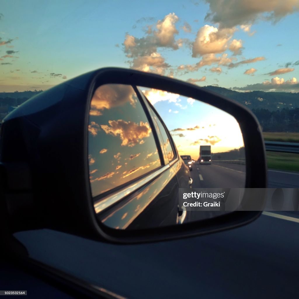 Beautiful image of road at sunset by car rear view mirror. Photo taken with iphone.