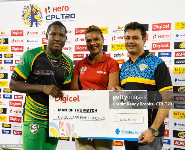 In this handout image provided by CPL T20, Rovman Powell of Jamaica Tallawahs receives the man of the match prize from Siobhan James-Alexander of...