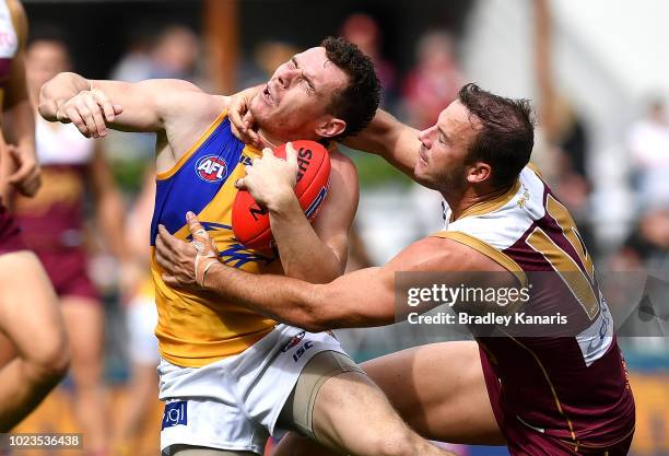 Luke Shuey of the Eagles is tackled by Josh Walker of the Lions during the round 23 AFL match between the Brisbane Lions and the West Coast Eagles at...