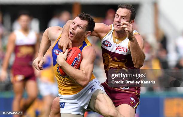 Luke Shuey of the Eagles is tackled by Josh Walker of the Lions during the round 23 AFL match between the Brisbane Lions and the West Coast Eagles at...