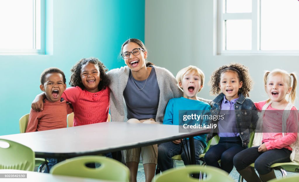 Multi-ethnic preschool teacher and students in classroom