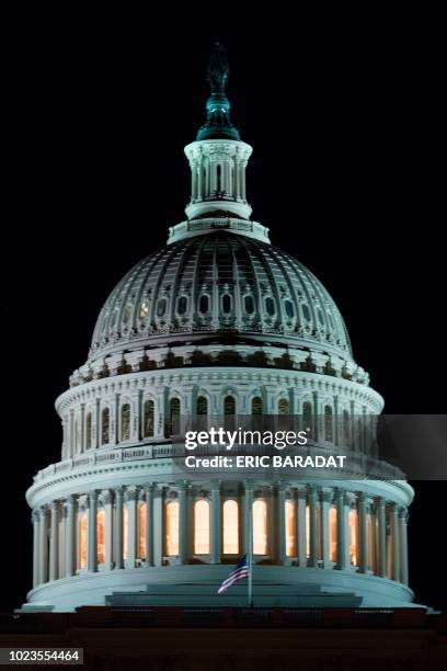 The US National flag flies at half-mast in front of the United States Capitol building in Washington a few hours after the death of US Republican...