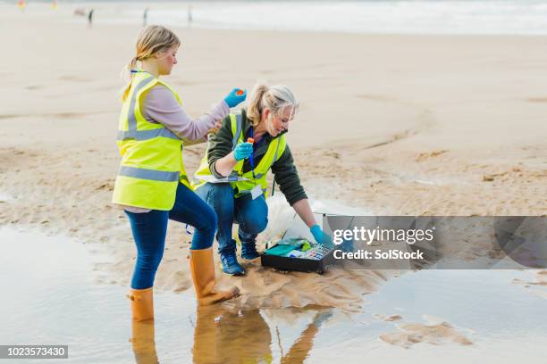 donne che prendono un campione d'acqua - campione scientifico foto e immagini stock