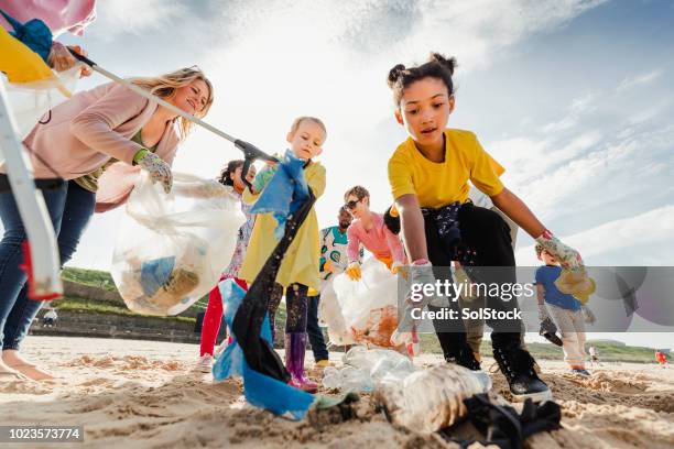 community volunteer groups on the beach - ocean pollution stock pictures, royalty-free photos & images