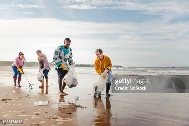 aktivisten, die gemeinsam etwas bewirken - volunteer beach stock-fotos und bilder