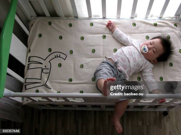 baby sleeping in the crib with pacifiers - おしゃぶり ストックフォトと画像