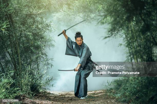 the japanese samurai are gripping the sword, preparing to fight. - samurai - fotografias e filmes do acervo