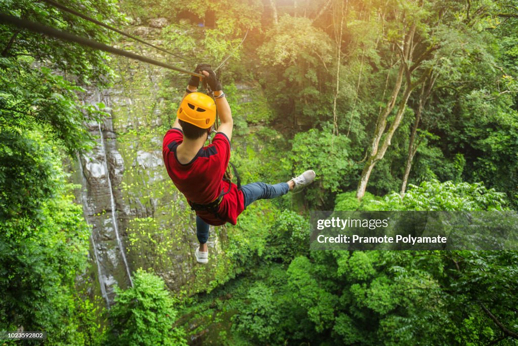 Freedom adult Man Tourist Wearing Casual Clothing On Zip Line Or Canopy Experience In Laos Rain Forest