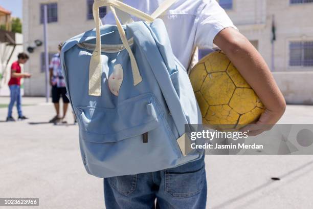 school kid with ball - school boy with bag stockfoto's en -beelden