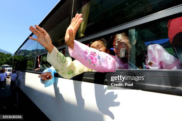 North Koreans on a bus hold hands of their South Korean relatives to bid farewell after the separated family reunion meeting at the Mount Kumgang...