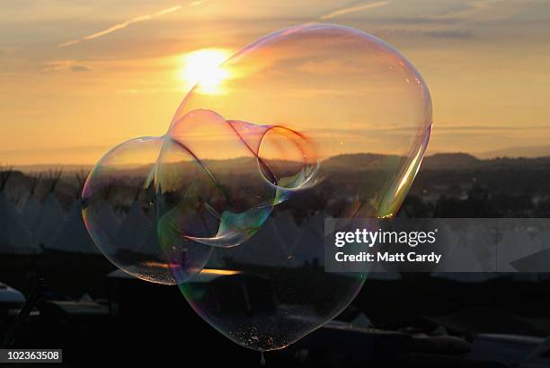 Soap bubble floats against the backdropThe first of the 140,000 music fans due at this year's Glastonbury Festival enjoy the sunset at Worthy Farm,...