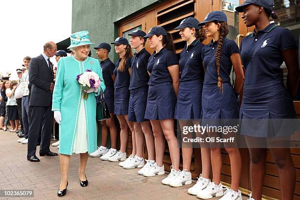 Queen Elizabeth II speaks to ball boys and girls as she attends the Wimbledon Lawn Tennis Championships on Day 4 at the All England Lawn Tennis and...