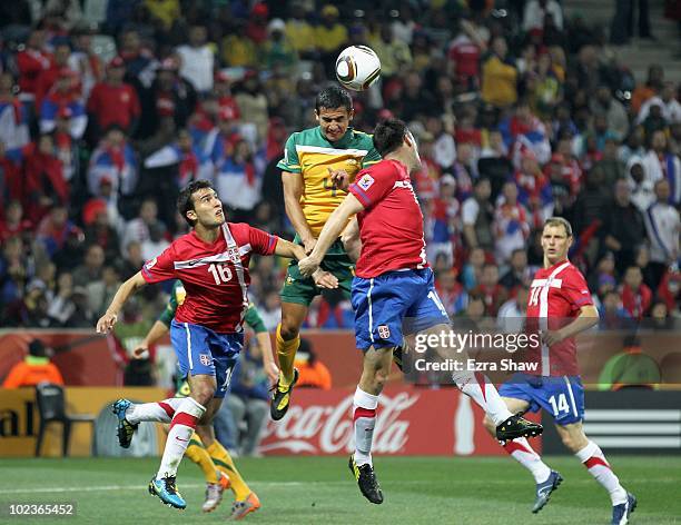 Tim Cahill of Australia goes up for the ball against Ivan Obradovic and Aleksandar Lukovic of Serbia during the 2010 FIFA World Cup South Africa...