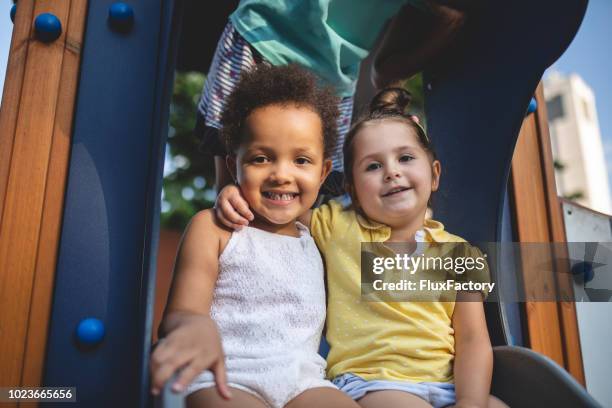 gorgeous toddler friends hugging and smiling together - family with two children stock pictures, royalty-free photos & images