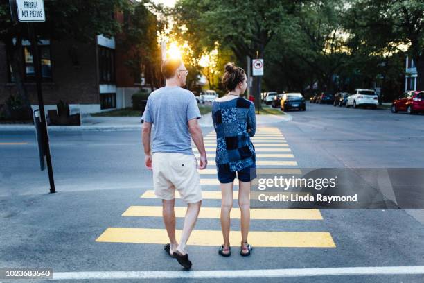 pedestrians crossing a street - pedestrian crossing sign stock-fotos und bilder