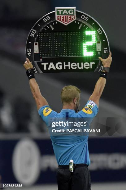 An assistant referee holds an electonic board displaying additional time during the French L1 football match between Toulouse and Nimes on August 25,...