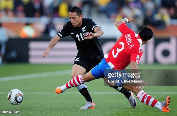 Leo Bertos of New Zealand evades the tackle by Claudio Morel of Paraguay during the 2010 FIFA World Cup South Africa Group F match between Paraguay...