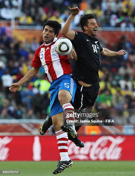 Julio Cesar Caceres of Paraguay tussles with Rory Fallon of New Zealand during the 2010 FIFA World Cup South Africa Group F match between Paraguay...