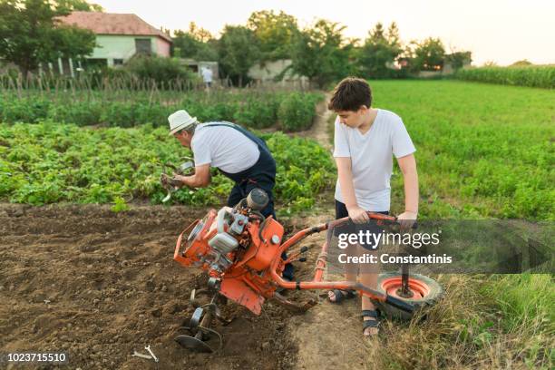 grandfather and grandson working on a mower - harrow agricultural equipment stock pictures, royalty-free photos & images