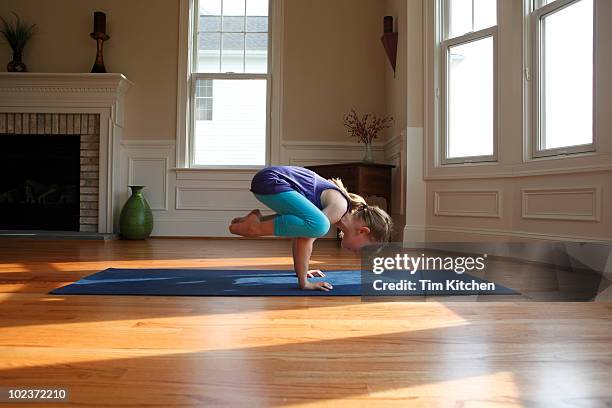 young girl practicing yoga in home, crow pose - children yoga stock pictures, royalty-free photos & images