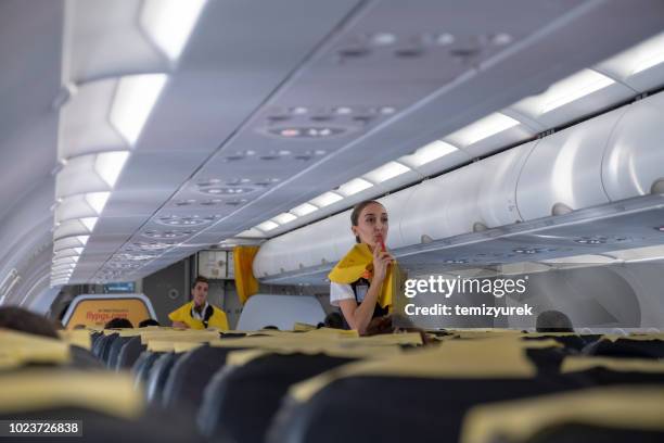 lucht gastvrouw geven veiligheidsinstructies voor vlucht - air stewardess stockfoto's en -beelden