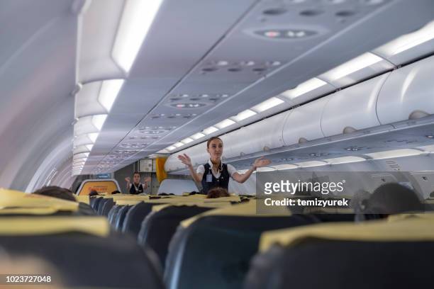 hostess aerea che dà istruzioni di sicurezza prima del volo - air stewardess foto e immagini stock