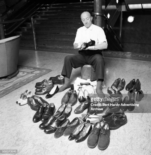 Bootblack cleans the passengers' shoes on the Cunard liner 'Queen Elizabeth', as she makes her way from Southampton to New York, May 1964.