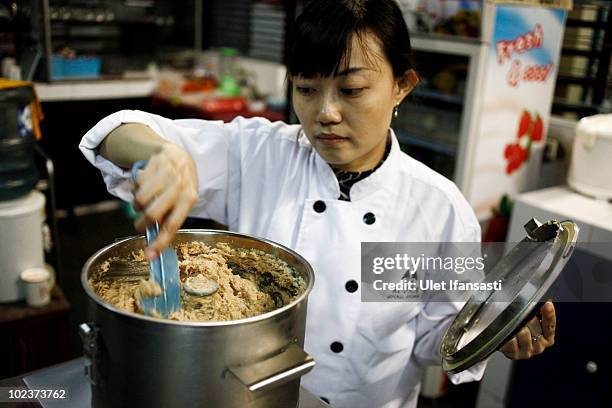 Chef processes cobra meat to make burgers at cobra restaurant on June 24, 2010 in Yogyakarta, Indonesia. The snakes are caught and processed into...