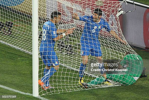 Vincenzo Iaquinta and Fabio Quagliarella of Italy topple Jan Mucha of Slovakia following Italy's first goal, during the 2010 FIFA World Cup South...