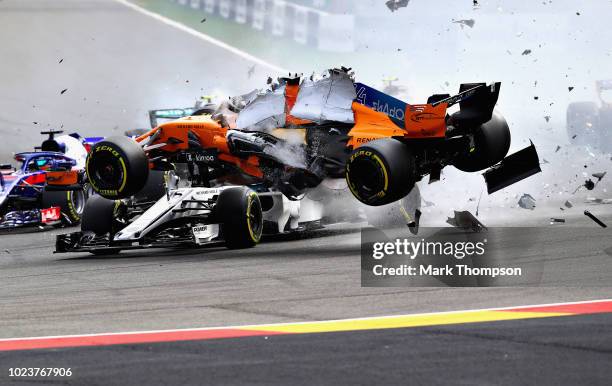 Fernando Alonso of Spain driving the McLaren F1 Team MCL33 Renault launches over the top of Charles Leclerc of Monaco driving the Alfa Romeo Sauber...