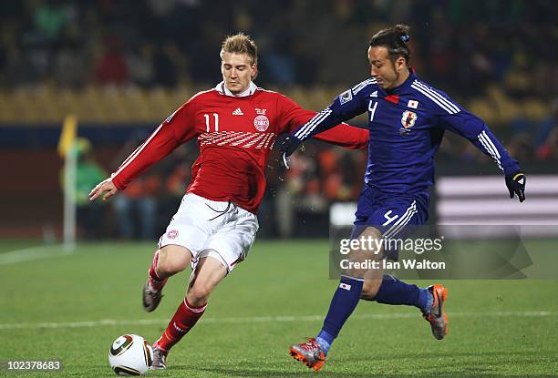 Marcus Tulio Tanaka of Japan challenges Nicklas Bendtner of Denmark during the 2010 FIFA World Cup South Africa Group E match between Denmark and...