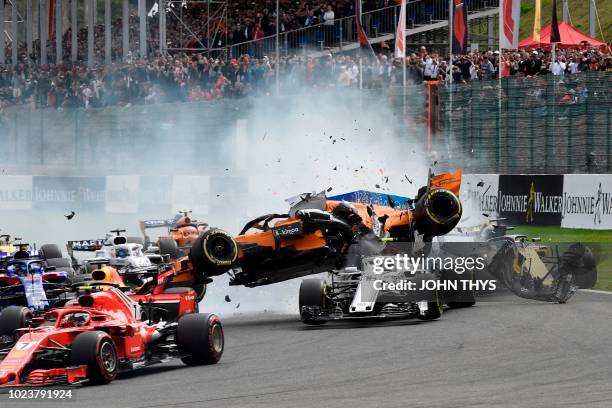 McLaren's Spanish driver Fernando Alonso crashes during the first lap of the Belgian Formula One Grand Prix at the Spa-Francorchamps circuit in Spa...
