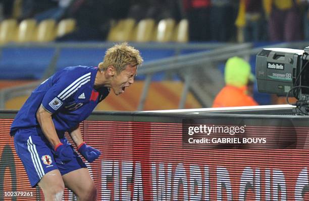 Japan's midfielder Keisuke Honda celebrates after scoring the opening goal during the Group E first round 2010 World Cup football match Denmark vs....