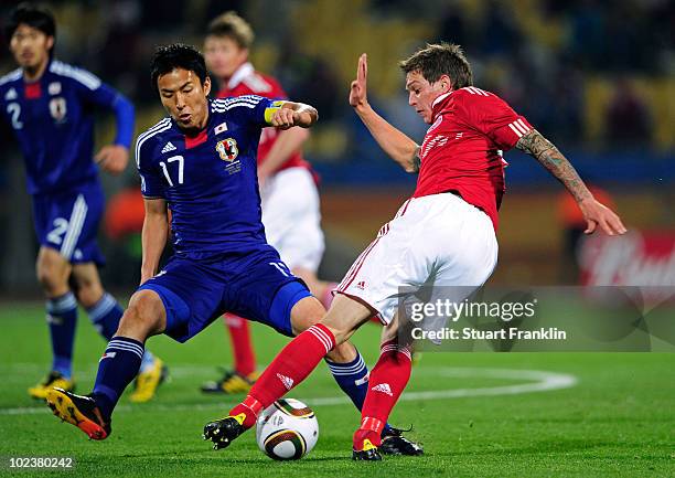 Daniel Agger of Denmark takes on Makoto Hasebe of Japan during the 2010 FIFA World Cup South Africa Group E match between Denmark and Japan at the...