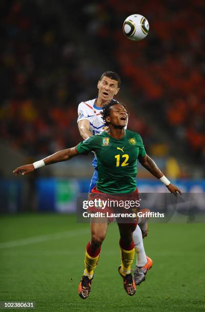 Khalid Boulahrouz of the Netherlands pushes Gaetan Bong of Cameroon as they jump for the ball during the 2010 FIFA World Cup South Africa Group E...