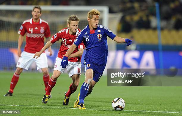 Japan's midfielder Keisuke Honda fight for the ball with Denmark's midfielder Martin Joergensen as Denmark's defender Daniel Agger watches during the...