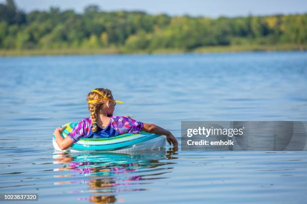 niña flotando en el interior tubo flotador juguete en el agua - tube girl fotografías e imágenes de stock