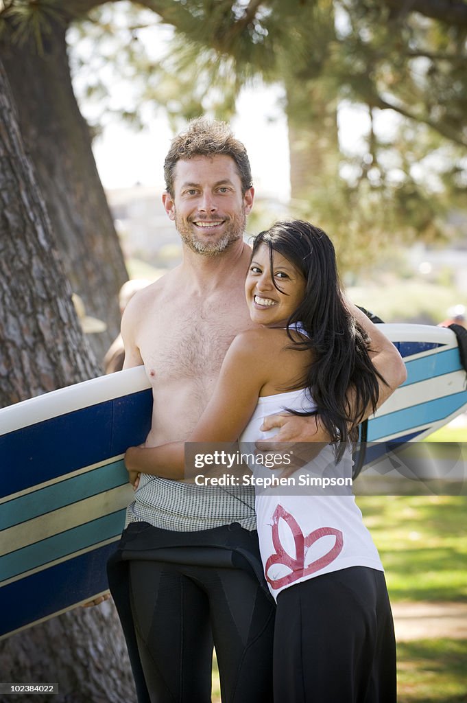 Portrait of couple with surfboard
