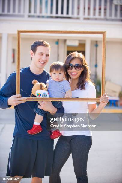 young couple with their infant - father and son picture frame stock pictures, royalty-free photos & images