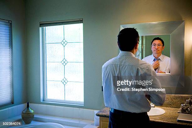 man dressing in front of bathroom mirror - standing mirror stock pictures, royalty-free photos & images