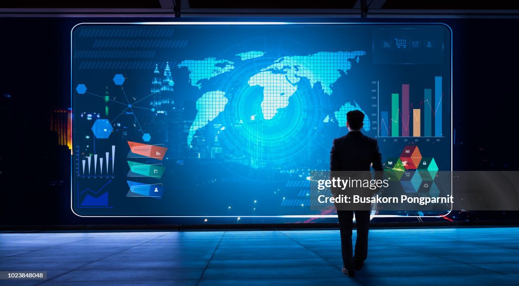 Business man looking financial graph icon on futuristic virtual screen with technology